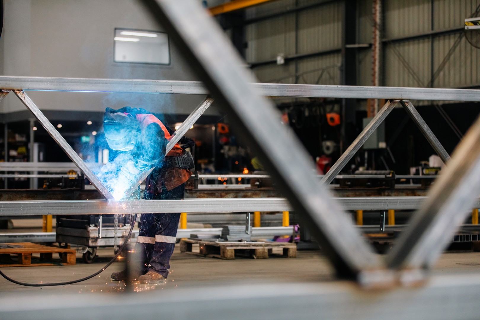 TechSpan team member welding structural steel inside the workshop