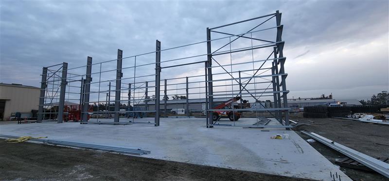 Engineered concrete slab and footing system prepared to support a steel building structure and long-term load performance.