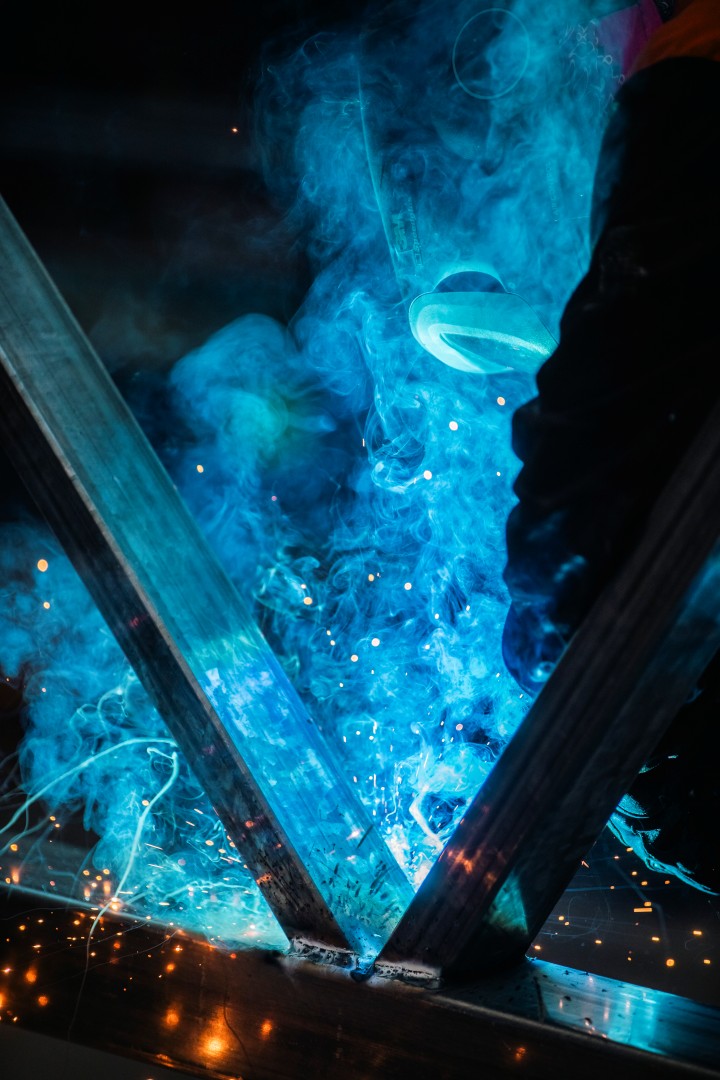 Structural steel welding with blue arc light and sparks during fabrication