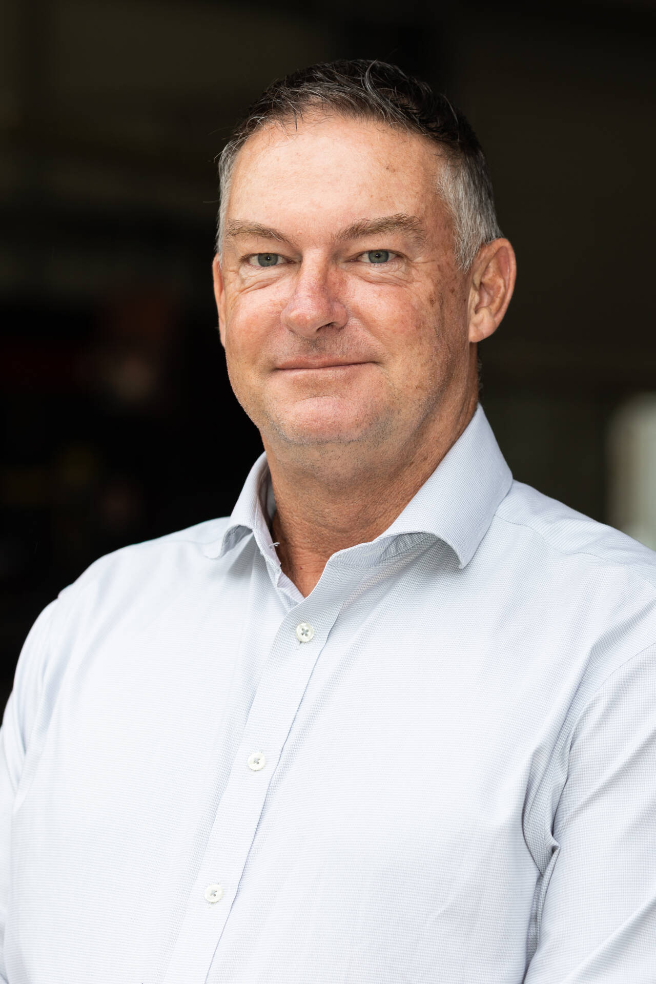 Portrait of Tyron Kilpatrick from TechSpan Building Systems standing in a workshop environment wearing a light business shirt.