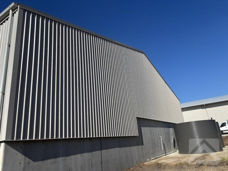Colourbond Trimdek wall cladding installed on an industrial effluent shed upgrade in Glenfield NSW, integrated with existing concrete infrastructure.