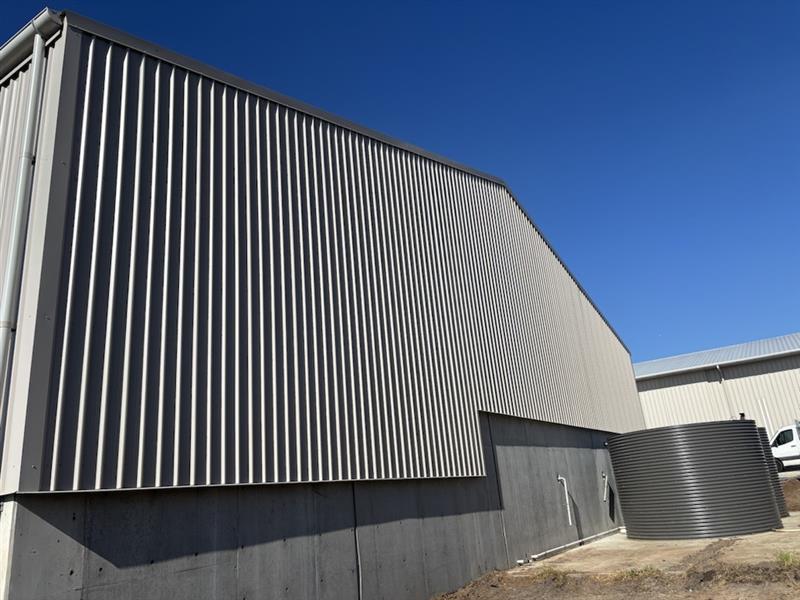 Colourbond Trimdek wall cladding installed on an industrial effluent shed upgrade in Glenfield NSW, integrated with existing concrete infrastructure.