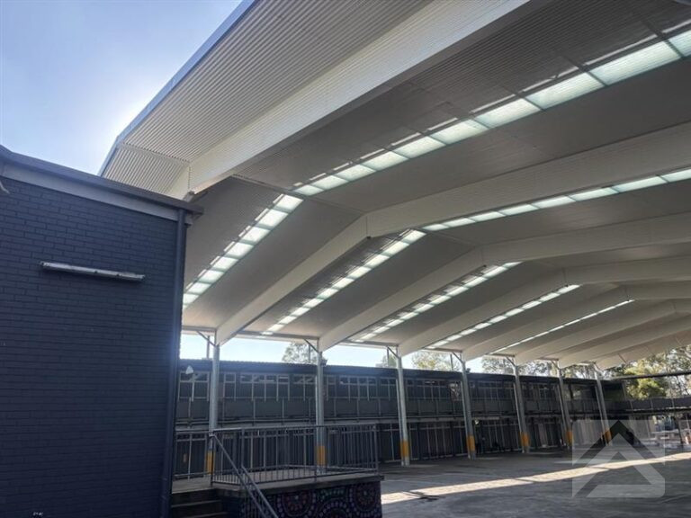 Side view of a large school COLA featuring a clear-span steel structure, insulated roof system and translucent roof panels for natural daylight.