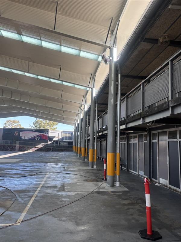 Side elevation of a large school COLA showing structural steel columns, insulated roof system and translucent roof panels above a covered outdoor learning area.