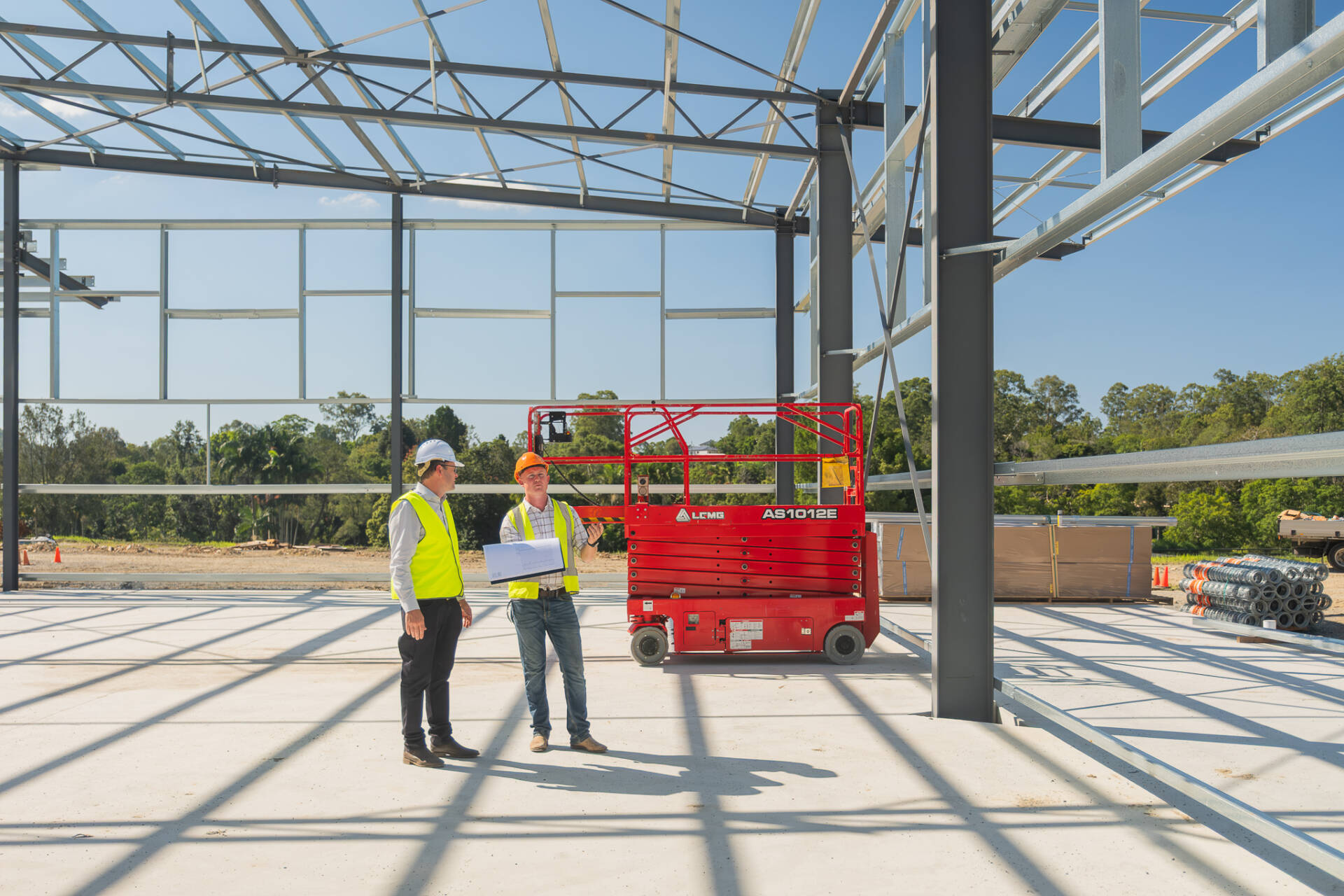 TechSpan representative and builder partner reviewing progress inside a structural steel building during construction.